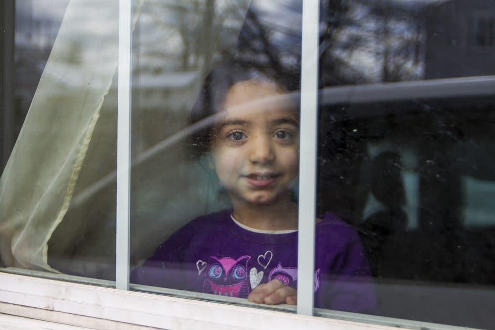 4-year-old Tuka Al-Nassar looks out the window. (Jesse Costa/WBUR)