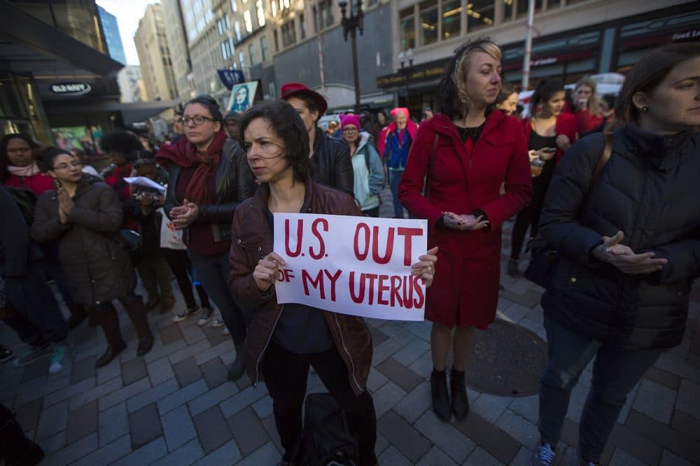 Noelle Cocoros hols a sign that reads,&quot;U.S. out of my uterus&quot; during the Day Without Women rally at Downtown Crossing. (Jesse Costa/WBUR)