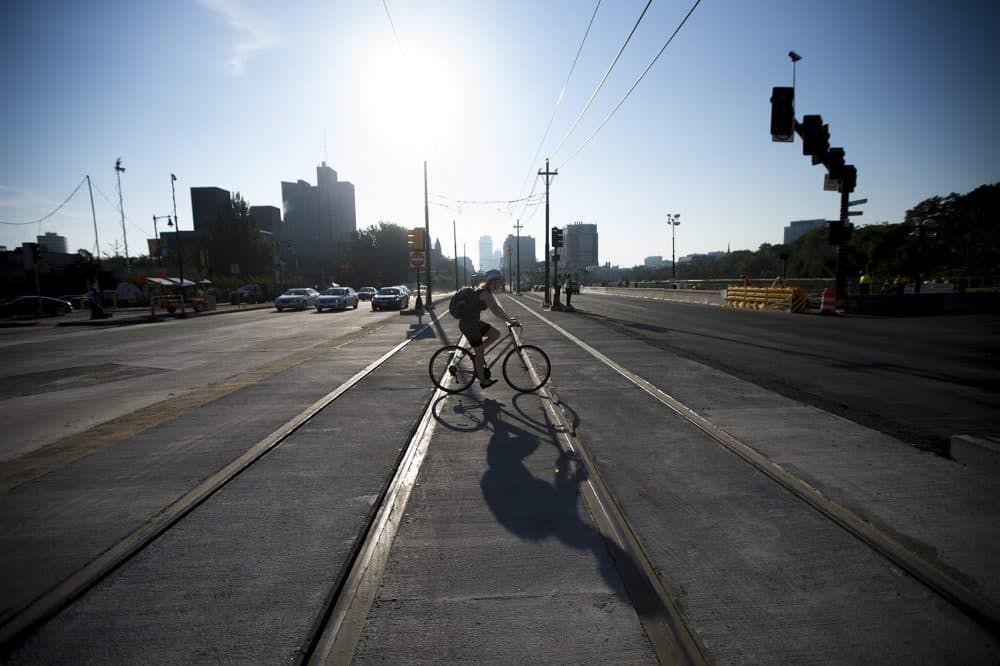 A cyclist crosses Commonwealth Ave Bridge on the first morning of iits reopening after being closed three weeks for repairs. (Jesse Costa/WBUR)