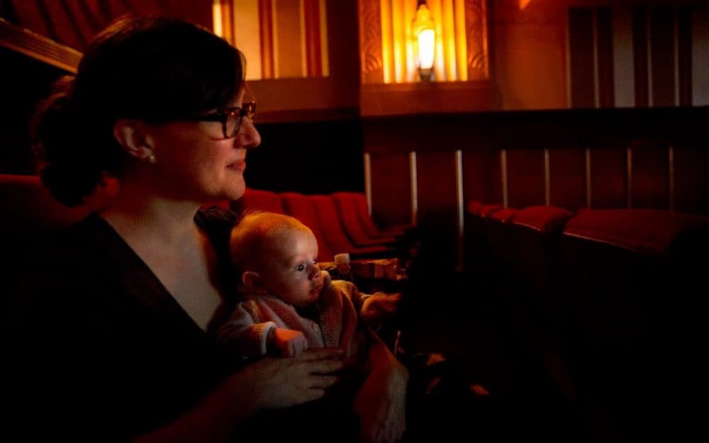 As the lights go down Leah Hampton and her 11-week-old son Will settle down to watch &quot;Faces Places.&quot; (Robin Lubbock/WBUR)