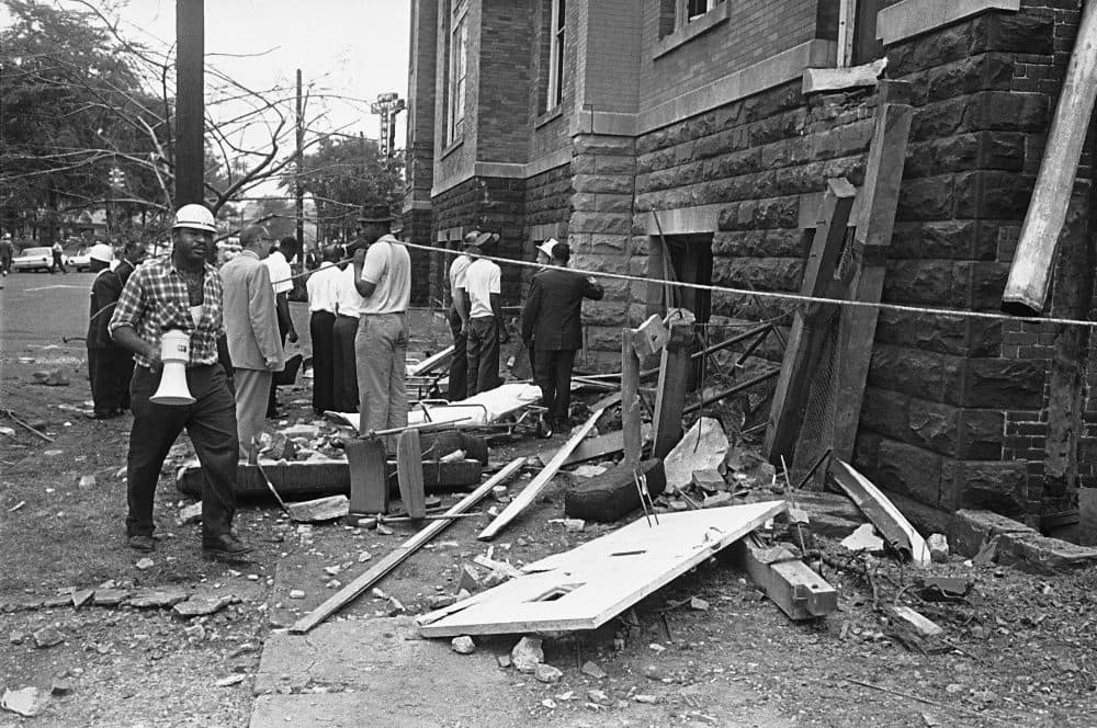 A civil defense worker and firemen walk through debris from an expolsion which struck the 16th street Baptist Church, killing and injuring several people, in Birmingham, Ala. on Sept. 15, 1963. (AP Photo)