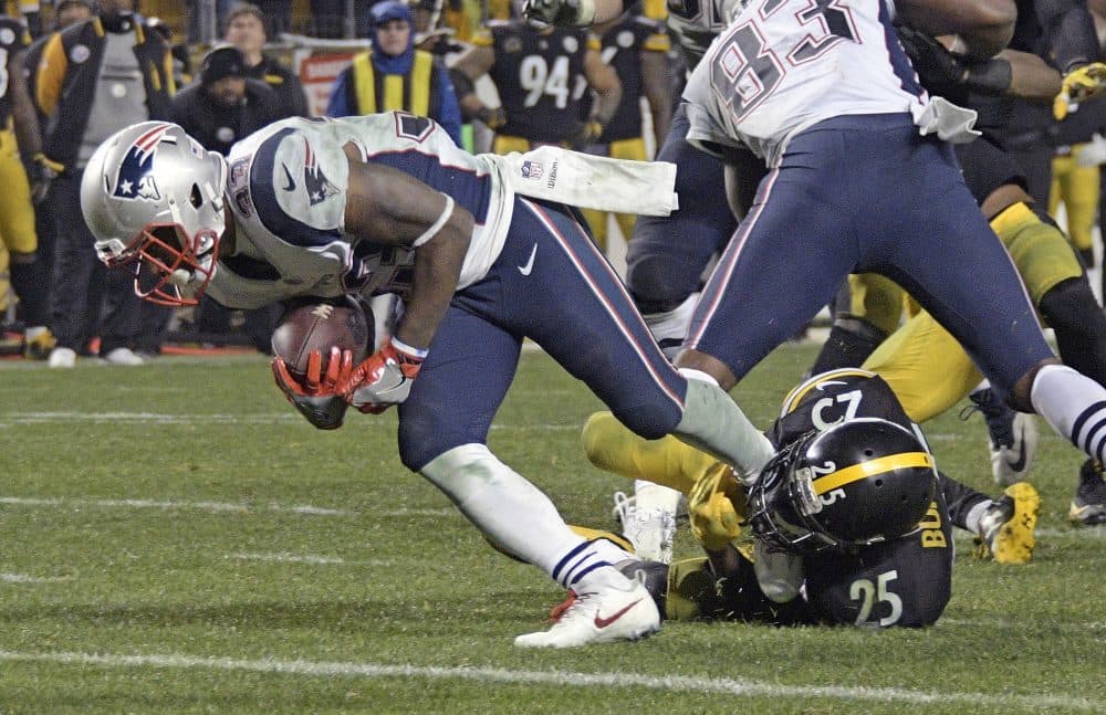 New England Patriots running back Dion Lewis (33) slips the tackle of Pittsburgh Steelers cornerback Artie Burns (25) for a touchdown. (Don Wright/AP)