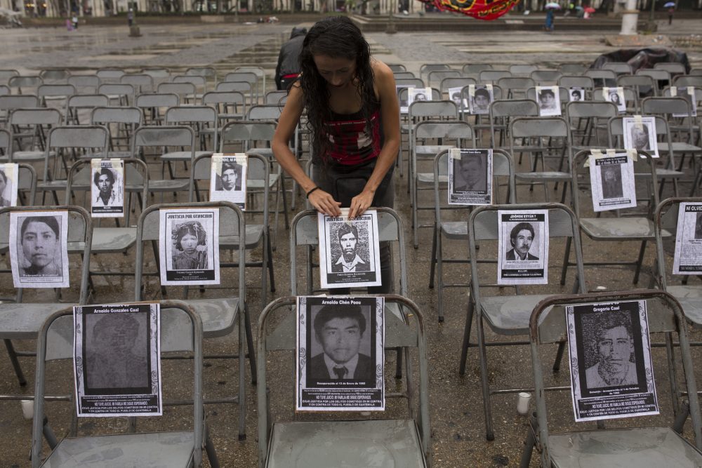 María Meza Paniagua adjunta el retrato de un desaparecido a una silla, en una ceremonia que marca el Día Nacional Contra la Desaparición Forzada, en Guatemala, el 21 de junio de 2017. Según grupos de derechos humanos, más de 40,000 personas fueron &quot;desaparecidas&quot; durante los 36 años del conflicto interno en Guatemala. (Moisés Castillo/AP)