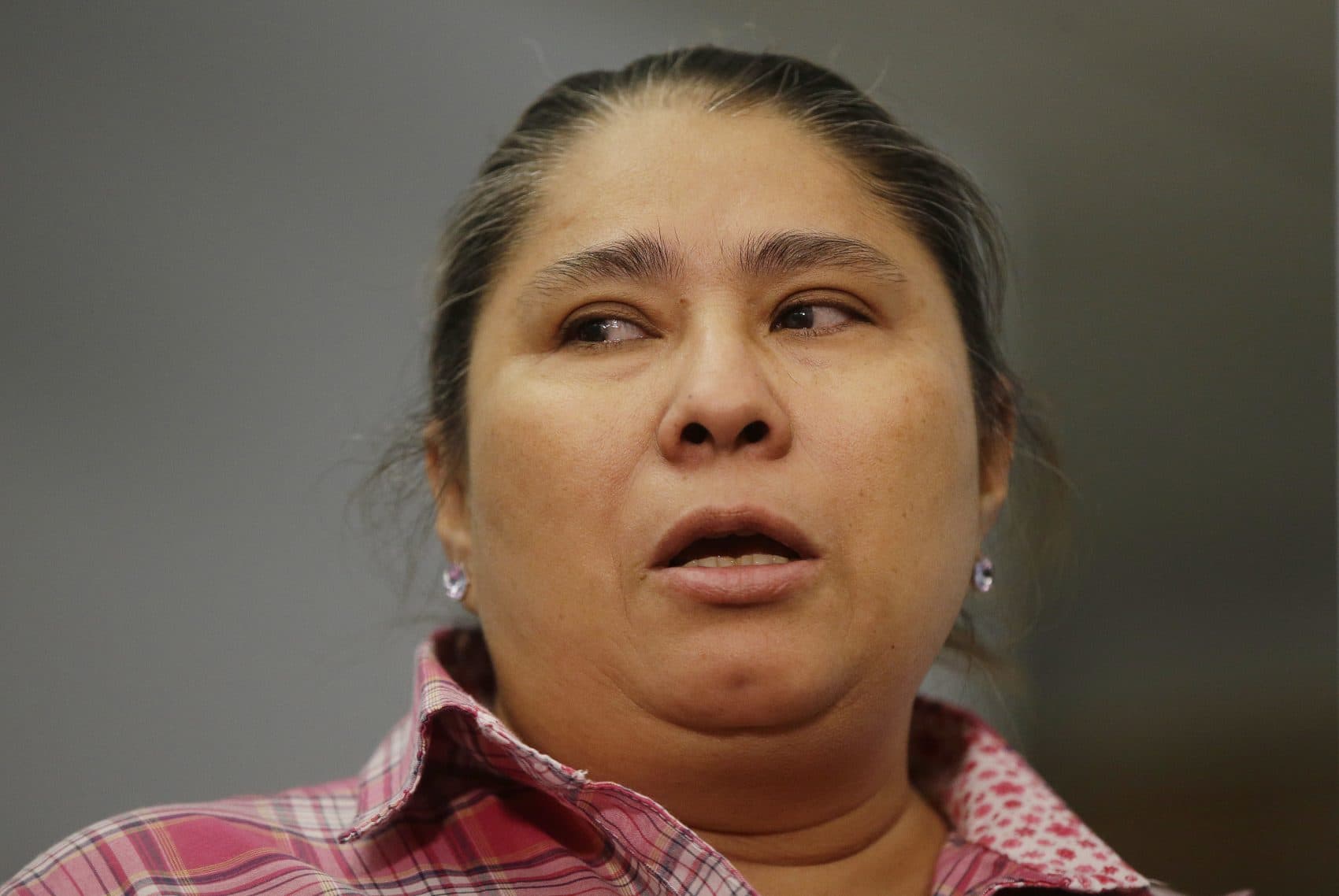 Gladys Fuentes, one of five female kitchen workers bringing a sexual harassment lawsuit against McCormick & Schmick's, recounts her experiences Tuesday in Boston. (Stephan Savoia/AP)