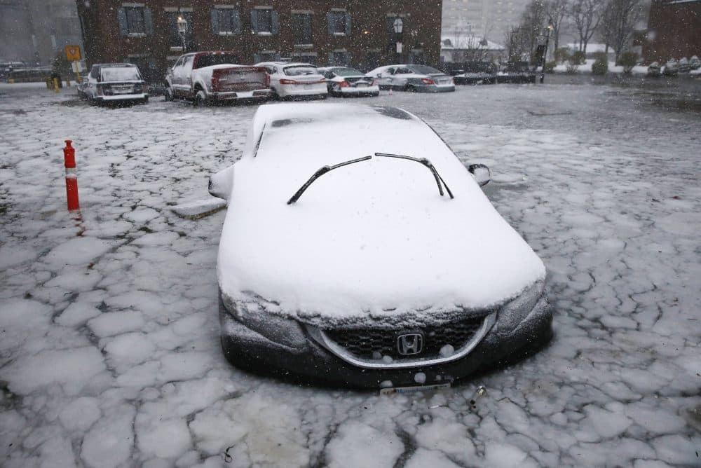 A car sits in floodwaters from Boston Harbor on Long Wharf in Boston. (Michael Dwyer/AP)