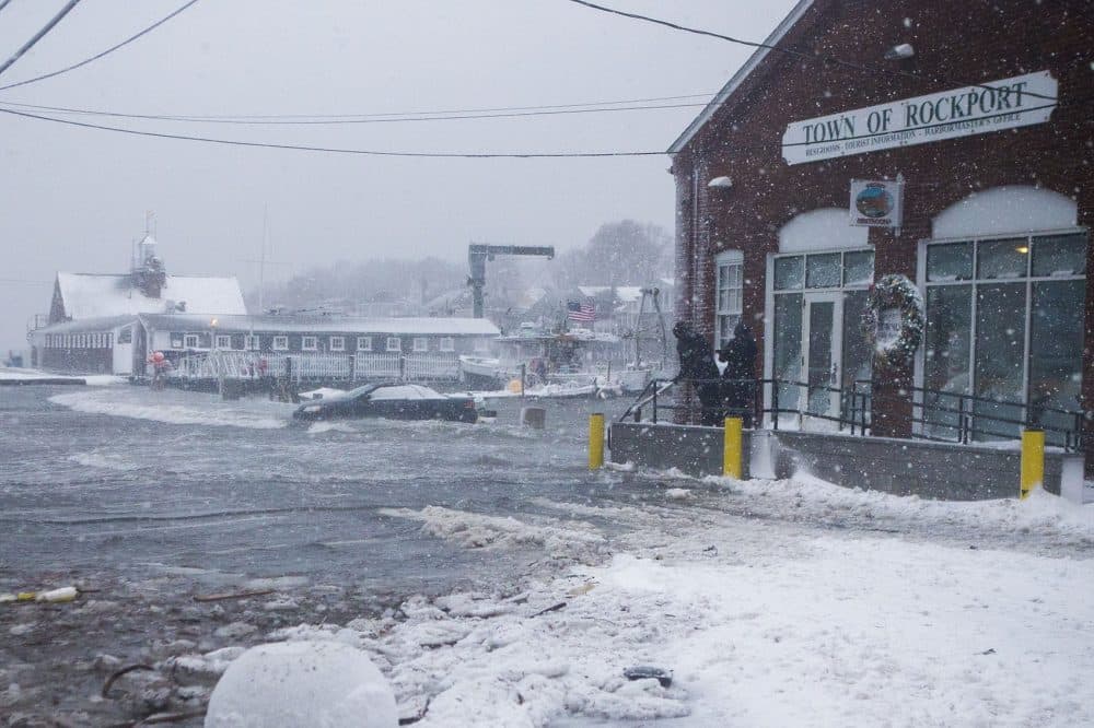 Ocean water begins to submerge a car on T Wharf in Rockport at high tide. (Jesse Costa/WBUR)