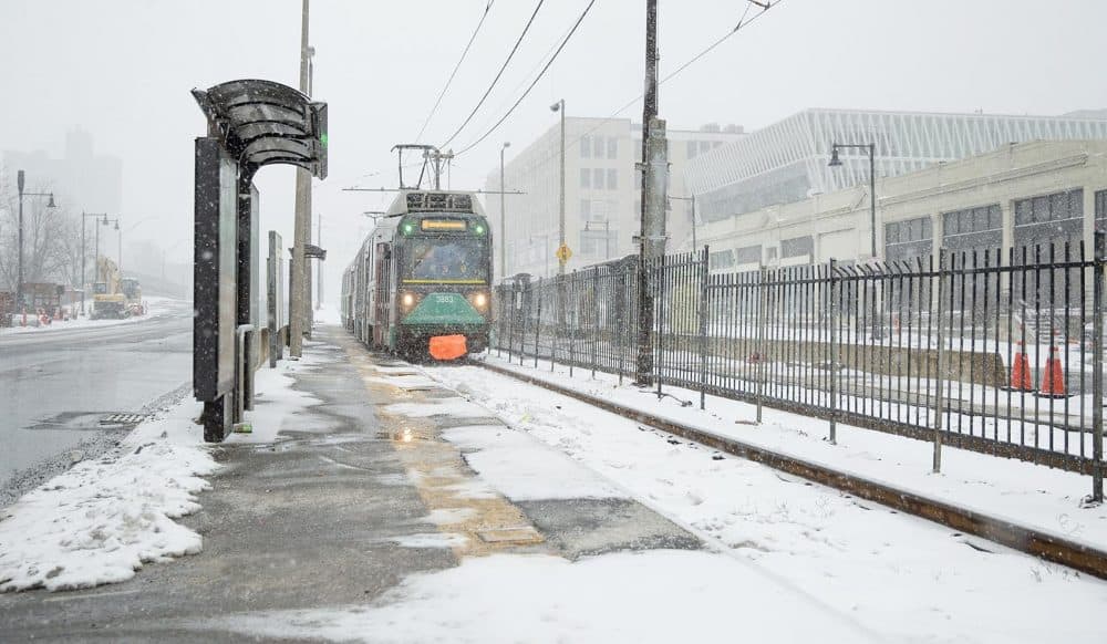 As snow falls at the start of the snowstorm, a Green Line train pulls into a deserted station on Commonweath Ave. (Robin Lubbock/WBUR)