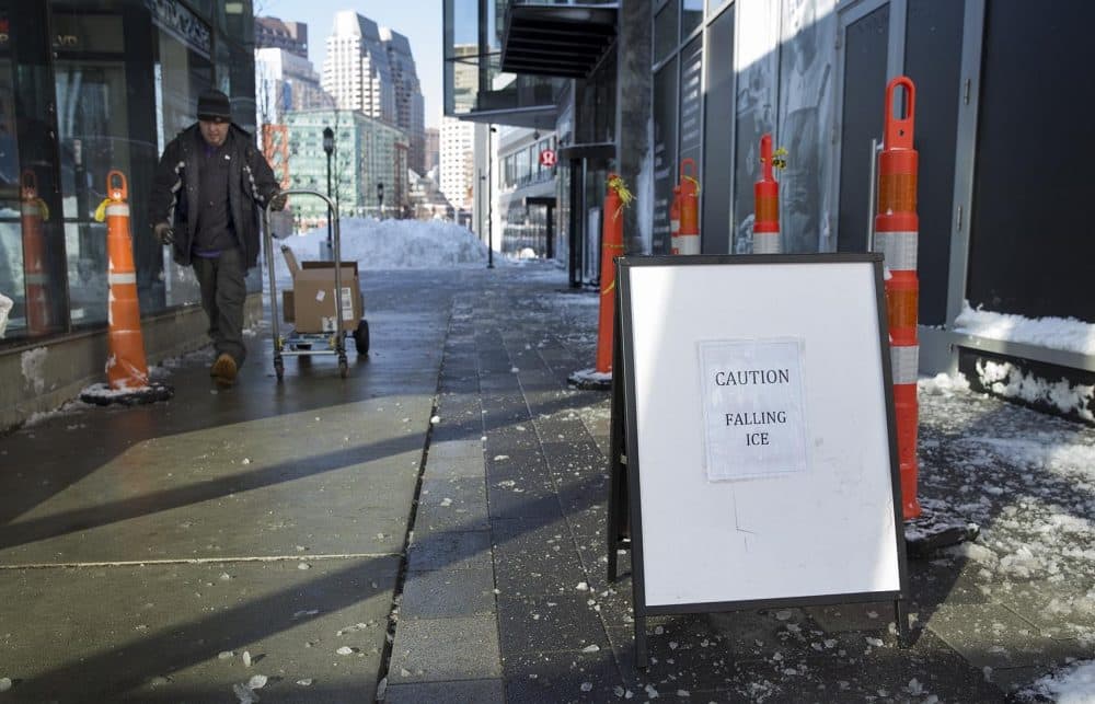A sign by a building in the seaport warns of falling ice. (Robin Lubbock/WBUR)