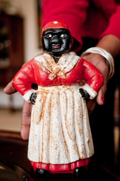 Dora Robinson holds the cast-iron figure of Aunt Jemima, originally used as a doorstop, which she found at a yard sale in upstate New York. (Ben James/NEPR)
