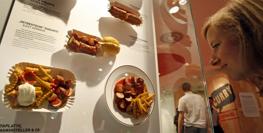 A woman looks at various currywurst dishes at the Deutsches Currywurst Museum in Berlin, Germany, in 2009. (Michael Sohn/AP)