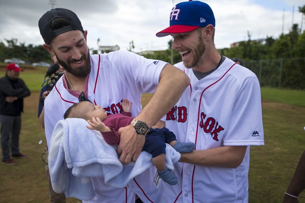Chris Sale hands baby Alex Valez very carefully over to teammate Rick Porcello. (Jesse Costa/WBUR)