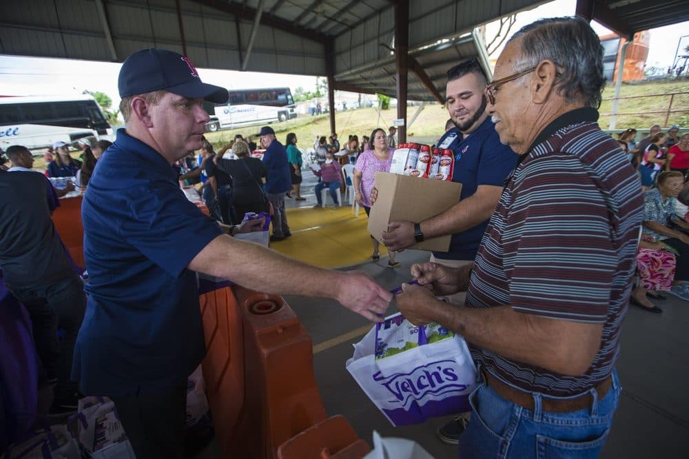 Boston Mayor Marty Walsh hands out relief supplies to residents of Caguas. (Jesse Costa/WBUR)