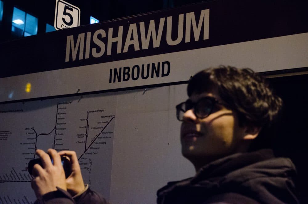 Miles takes a photo at Mishawum station in Woburn. (Elizabeth Gillis/WBUR)