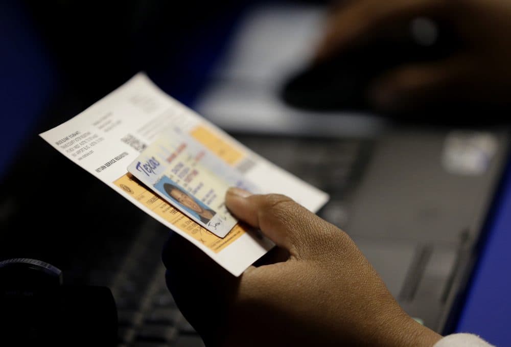In this Feb. 26, 2014 file photo, an election official checks a voter's photo identification at an early voting polling site in Austin, Texas. (Eric Gay/AP)