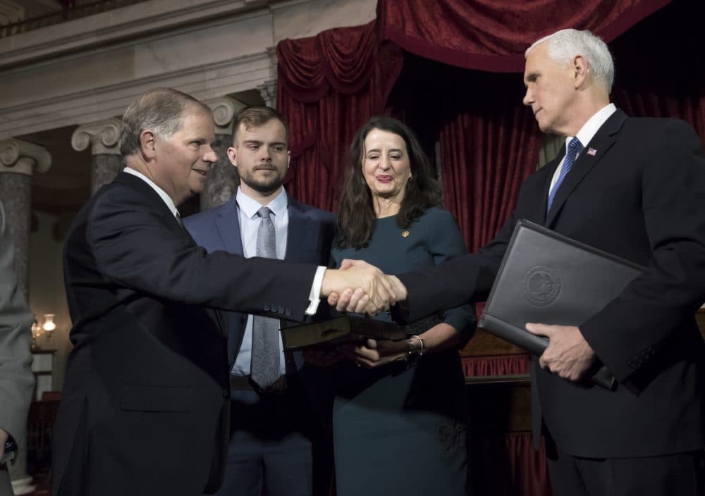 Vice President Mike Pence, right, shakes hands with Sen. Doug Jones, D-Ala., left, after administering the Senate oath of office during a mock swearing in ceremony in the Old Senate Chamber to Jones, with his wife Louise Jones, second from right, Wednesday, Jan. 3, 2018 on Capitol Hill in Washington. (J. Scott Applewhite/AP)