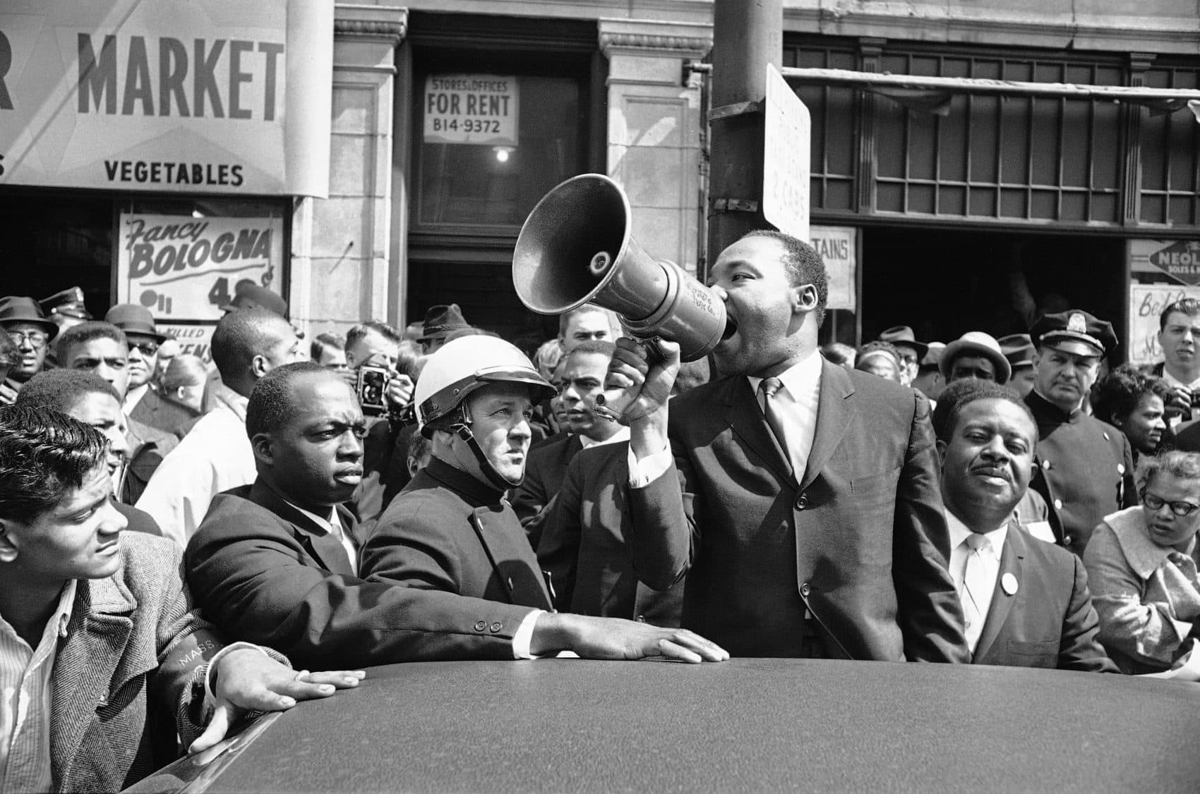 Dr. Martin Luther King Jr addresses a crowd with a bull horn in Roxbury on April 22, 1965. (AP)
