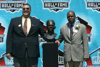 Fritz Pollard III (left) and Dr. Steven Towns pose with the bust of their grandfather, Fritz Pollard, during the 2005 NFL Hall of Fame induction ceremony in Canton, Ohio. (Jonathan Daniel/Getty Images)