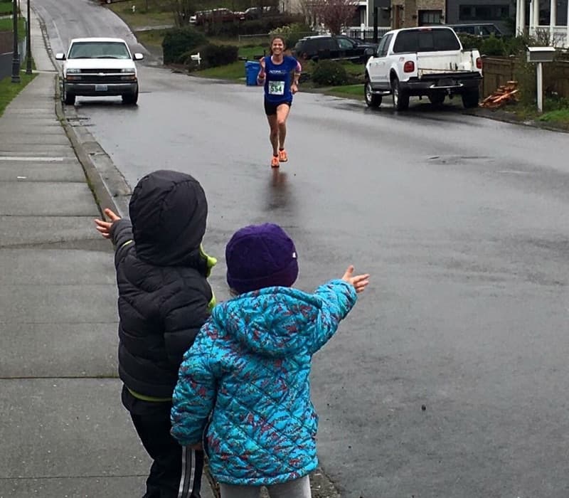 Kate during the 2016 Tacoma St. Patrick's Day Half-Marathon. Her daughter, Grace, and her friend, Charlie, watch along in the foreground. (Courtesy Kate Landau)
