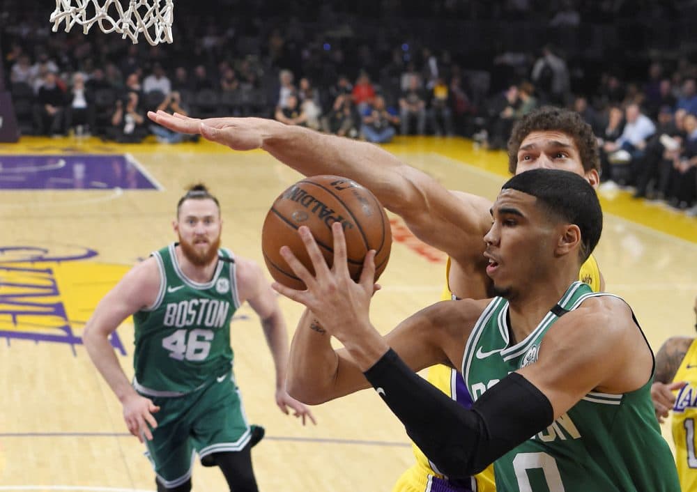 Boston Celtics forward Jayson Tatum, right, passes the ball as Los Angeles Lakers center Brook Lopez, behind, defends and center Aron Baynes, of Australia, watches during the first half of an NBA basketball game Tuesday, Jan. 23, 2018, in Los Angeles. (AP Photo/Mark J. Terrill)