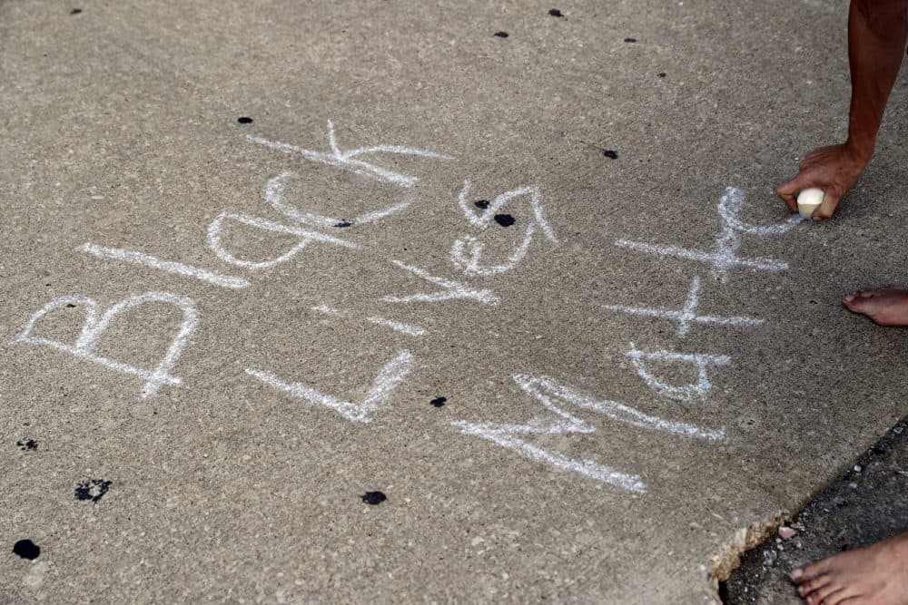 A protester writes, &quot;Black Lives Matter,&quot; on the ground with a chalk as protesters gather, Friday, Sept. 15, 2017, in downtown St. Louis, after a judge found a white former St. Louis police officer, Jason Stockley, not guilty of first-degree murder in the death of a black man, Anthony Lamar Smith, who was fatally shot following a high-speed chase in 2011. (AP Photo/Jeff Roberson)