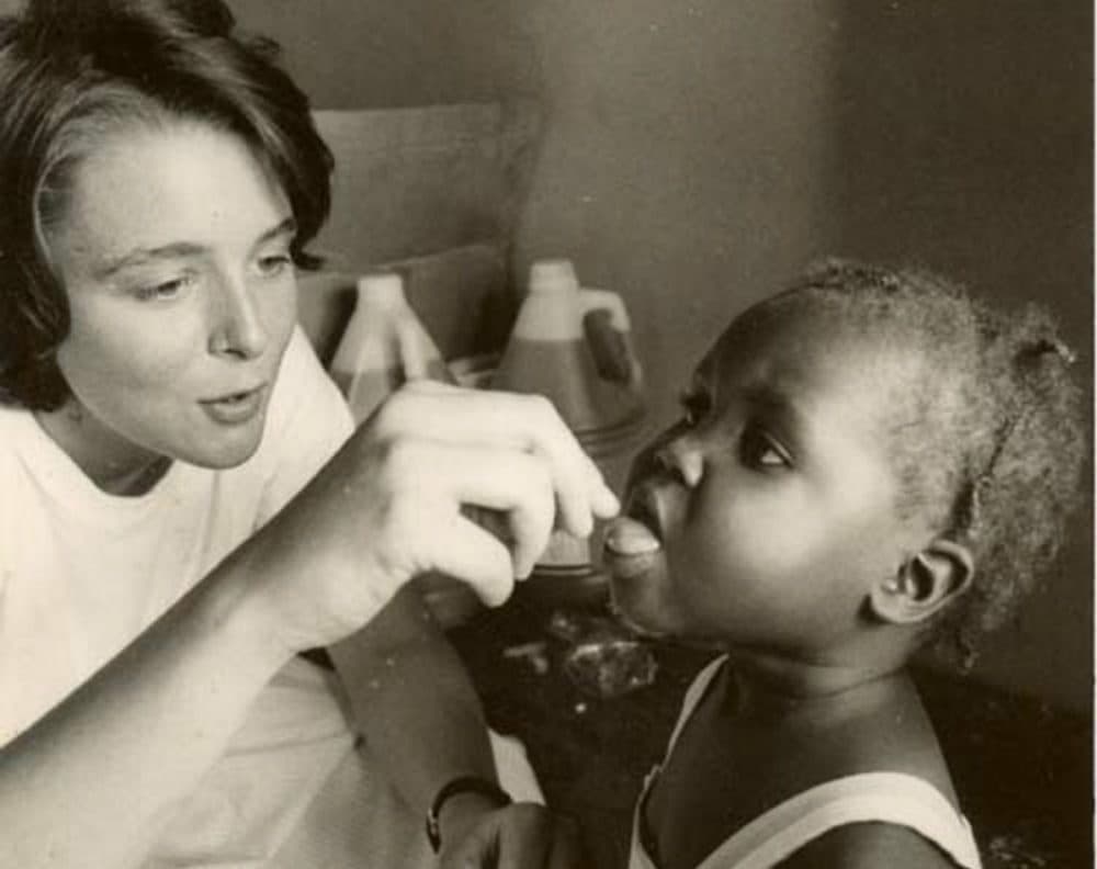 The author, pictured in the 1980s, gives a dose of medication to an unidentified Haitian girl. (Courtesy of Partners in Health)