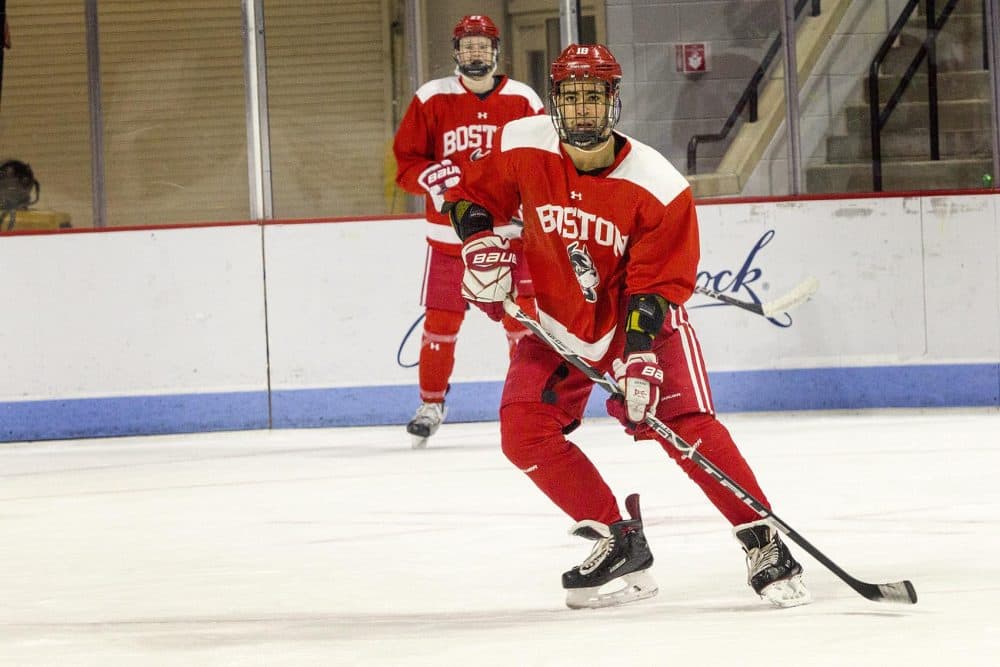 Forward Jordan Greenway looks for a pass as Brady Tkachuk watches from the boards. (Robin Lubbock/WBUR)