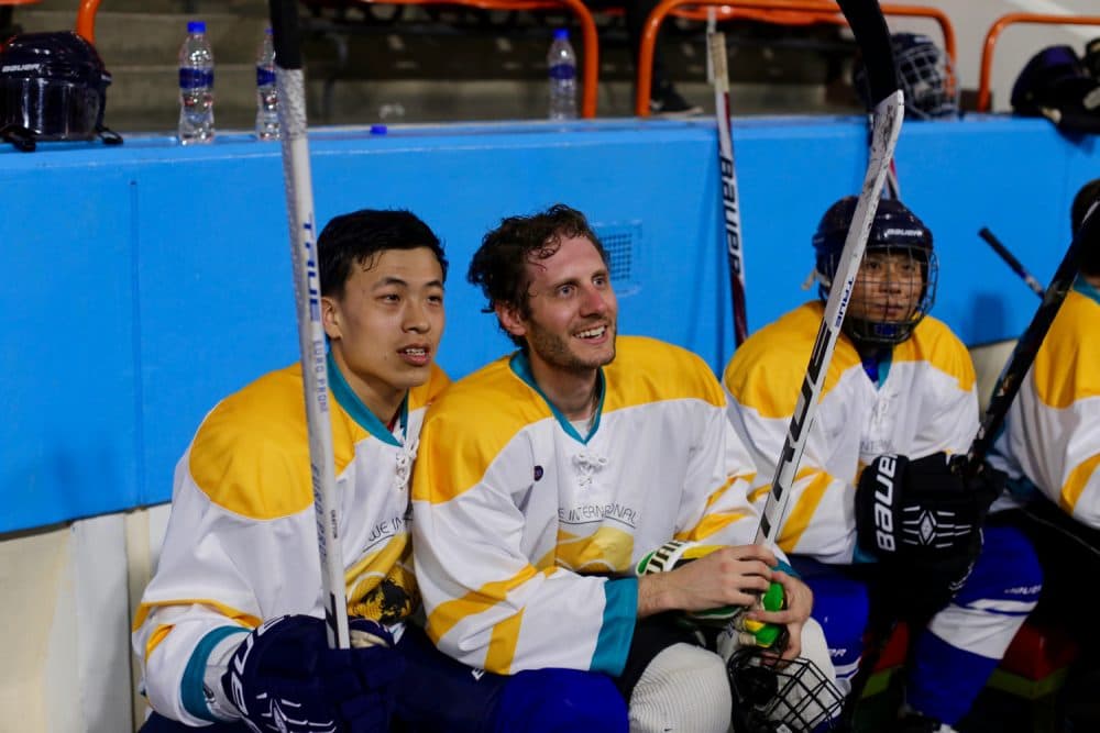 Alex sits with one of his newest linemates in his final contest in North Korea. (Courtesy Alex Frecon)