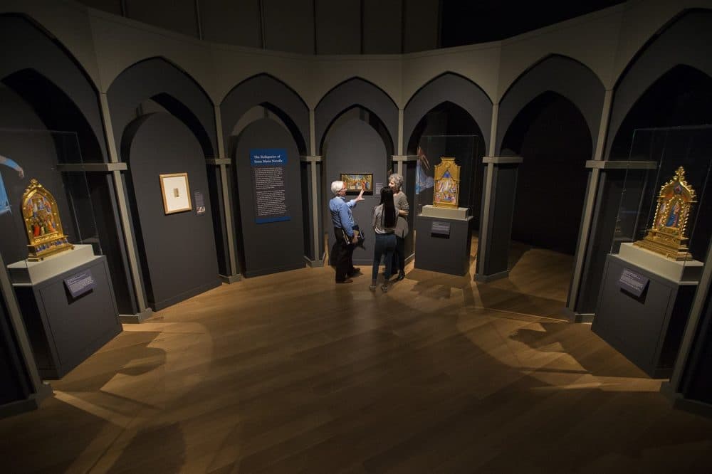 Gardner Museum visitors explore the space where the four Fra Angelico reliquaries have been reunited in order to complete a visual narrative of the Virgin Mary. (Jesse Costa/WBUR)