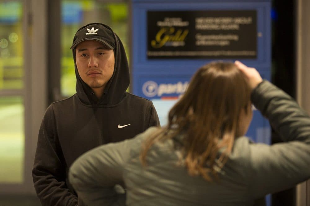 Erwin Macario watches as his brother is escorted through security to board a flight out of Logan Airport. (Jesse Costa/WBUR)