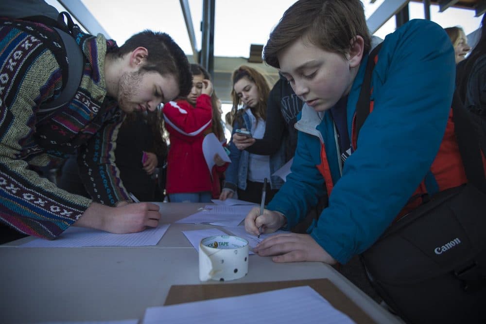 Students write letters to legislators at Trum Field. (Jesse Costa/WBUR)
