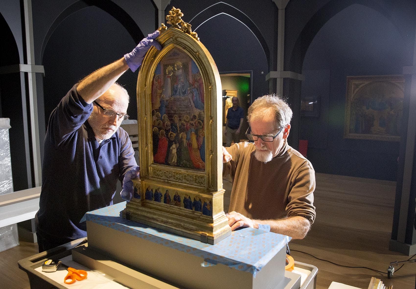 The Isabella Stewart Gardner Museum's chief conservator Gianfranco Pocobene and senior preparator David Kalan prepare the display space for Fra Angelico's "Coronation of the Virgin." (Robin Lubbock/WBUR)