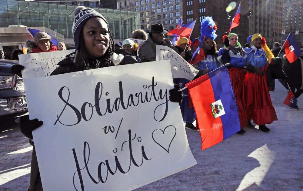 Haitian activists and immigrants protest on Boston City Hall Plaza on Jan. 26. Haitian community leaders complained last week that the Trump administration's delays in re-registering those living in the U.S. legally through the Temporary Protected Status program would lead to job losses, travel problems and other issues for Haitians. (Charles Krupa/AP)