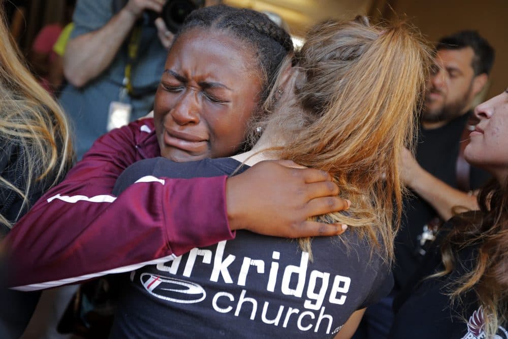 Marla Eveillard, 14, cries as she hugs friends before the start of a vigil at the Parkland Baptist Church, for the victims of the Marjory Stoneman Douglas High School shooting, which happened Wednesday, in Parkland, Fla., Thursday, Feb. 15, 2018. (Gerald Herbert/AP)