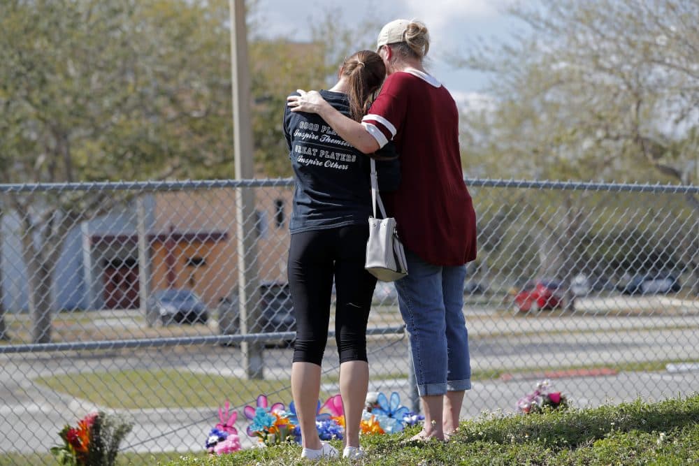 Hadley Sorensen, 16, a student at Marjory Stoneman Douglas High School, is comforted by her mother Stacy Sorensen at a makeshift memorial outside the school in Parkland, Fla., Sunday, Feb. 18, 2018, where 17 people were killed in a mass shooting. (Gerald Herbert/AP)
