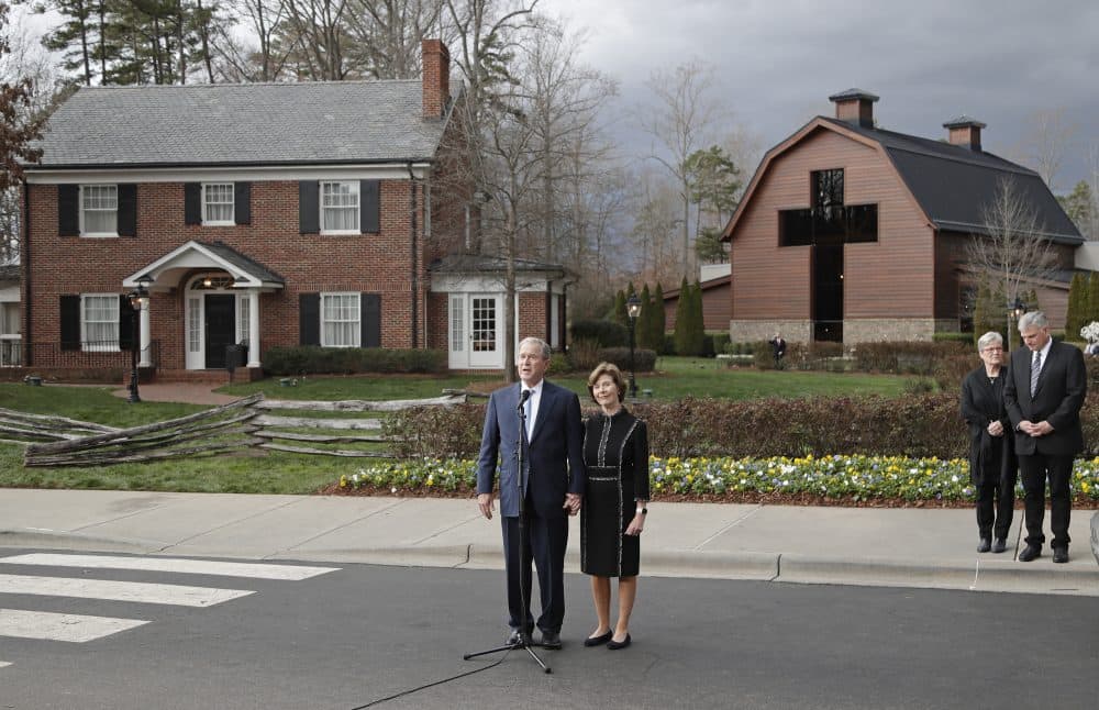 Former President George W. Bush, left, speaks to the media as wife Laura Bush, left, and Franklin Graham, back right, and his wife Jane Graham, back left, listen after paying their respects to Billy Graham during a public viewing at the Billy Graham Library in Charlotte, N.C., Monday, Feb. 26, 2018. (Chuck Burton/AP)