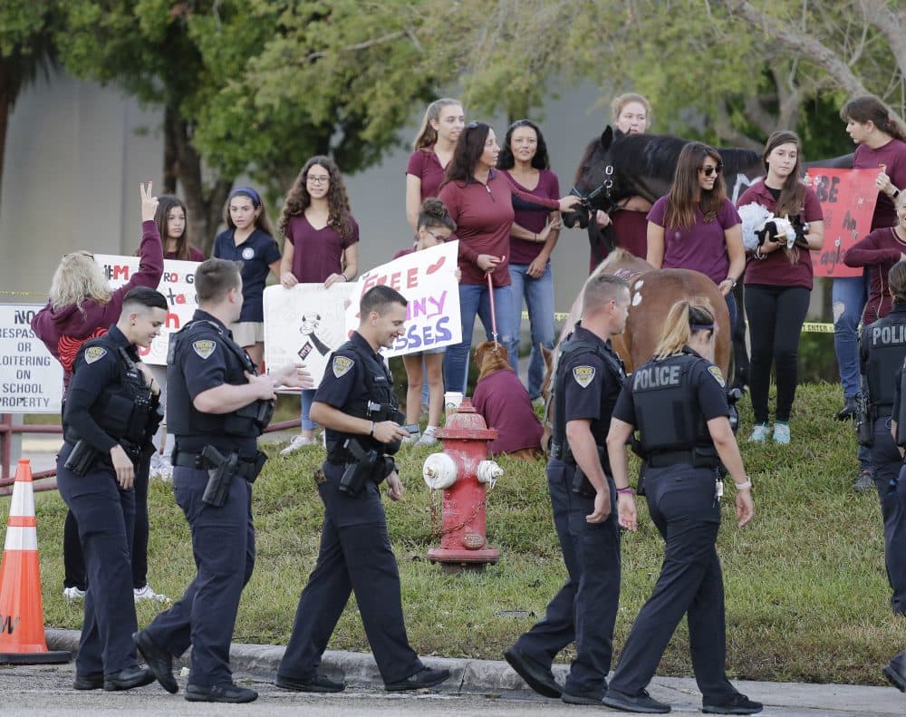 Police escort students arriving at Marjory Stoneman Douglas High School in Parkland, Fla., Wednesday, Feb. 28, 2018, on their first day back at the school since a former student opened fire there with an assault rifle, killing 17 people. (Terry Renna/AP)