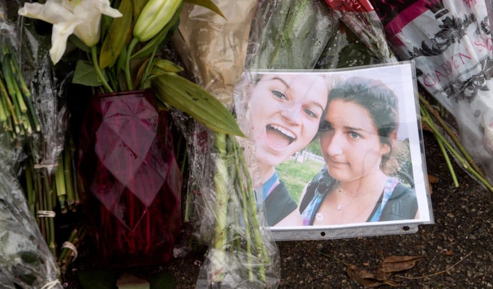 A photograph of Adrienne Garrido, 17, and Talia Newfield, 16, at the roadside memorial. (Max Larkin/WBUR)