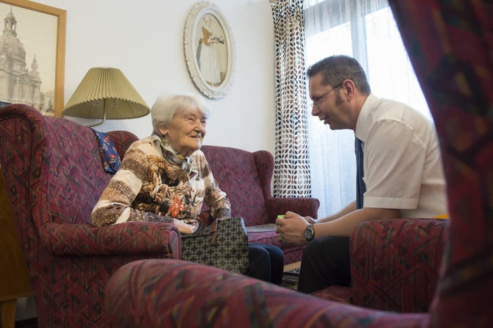 In this May 17, 2017 photo resident Gerda Noack talks with residence director Gunter Wolfram in the Alexa Seniors' Residence in Dresden, eastern Germany. The retirement home has recreated the communist era of the former GDR in two living-rooms to help residents with Alzheimer's and dementia. (AP Photo/Jens Meyer)