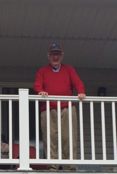 The author's father watching a parade from the porch of his condominium.