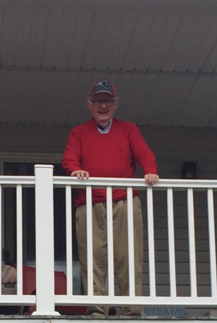 The author's father watching a parade from the porch of his condominium.