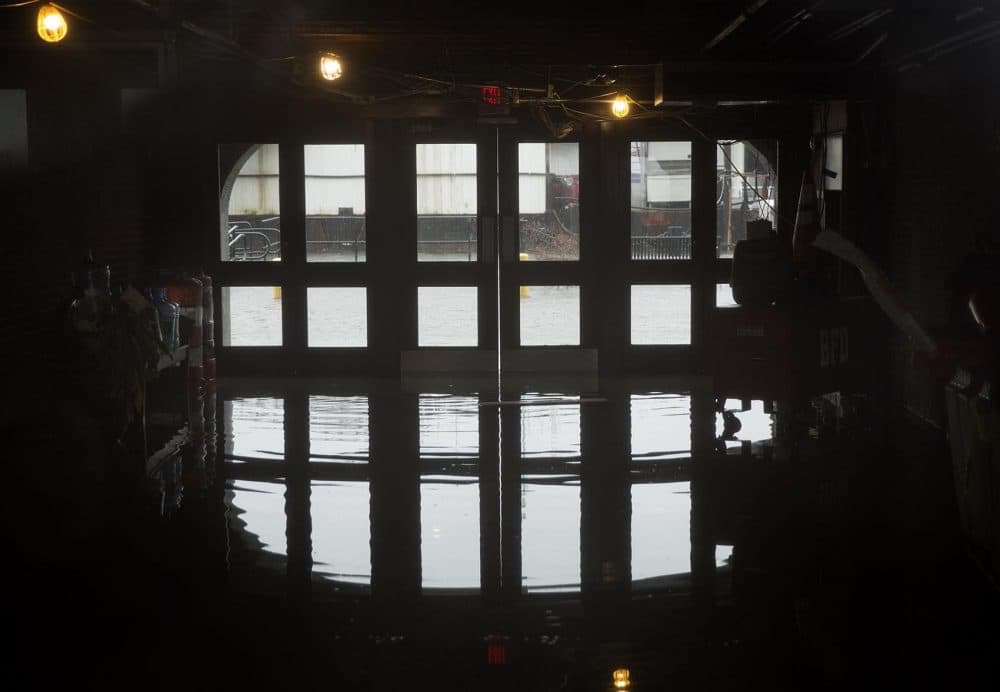 Flood waters seep under the doors of 66 Long Wharf. (Robin Lubbock/WBUR)