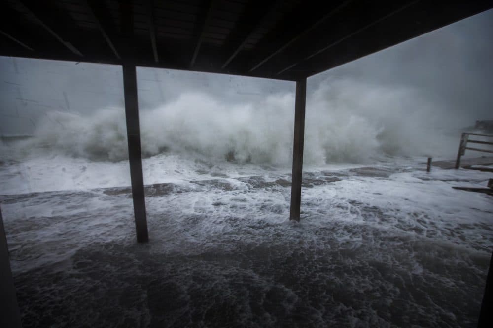 Waves crash along the seawall on Oceanside Drive in Scituate. (Jesse Costa/WBUR)