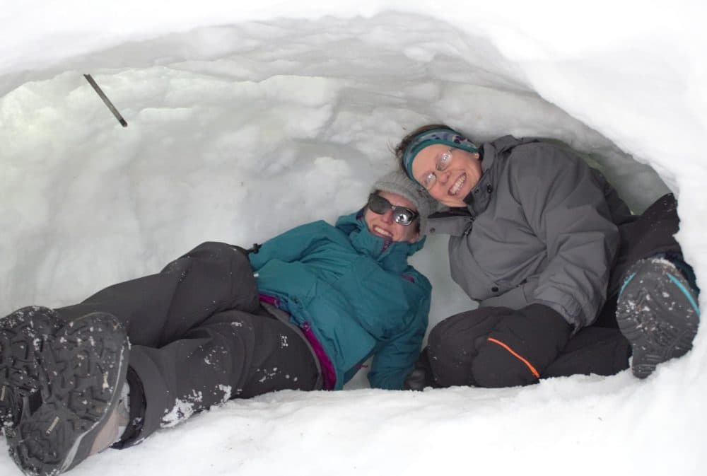 Winter survival skills students cozy up inside a quinzhee snow shelter. (Annie Ropeik/NHPR)