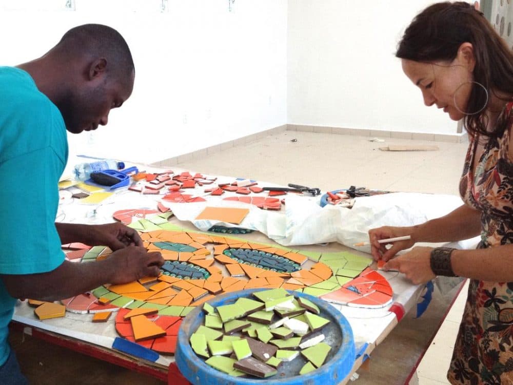 Artist Laurel True works with trainee Mario Jeudi on mosaics for a hospital in Mirebalais, Haiti. (Courtesy Laurel True)
