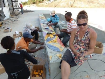 Laurel True at work with her team on a mosaic seat wall outside the Mirebalais hospital. (Courtesy Laurel True)