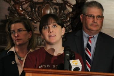 Erin Heim, of Somerville, a 2008 graduate of the Marjory Stoneman Douglas High, speaks at the State House with extreme risk protective order bill sponsors Rep. Marjorie Decker, left, and Rep. David Linsky. (Sam Doran/State House News Service)