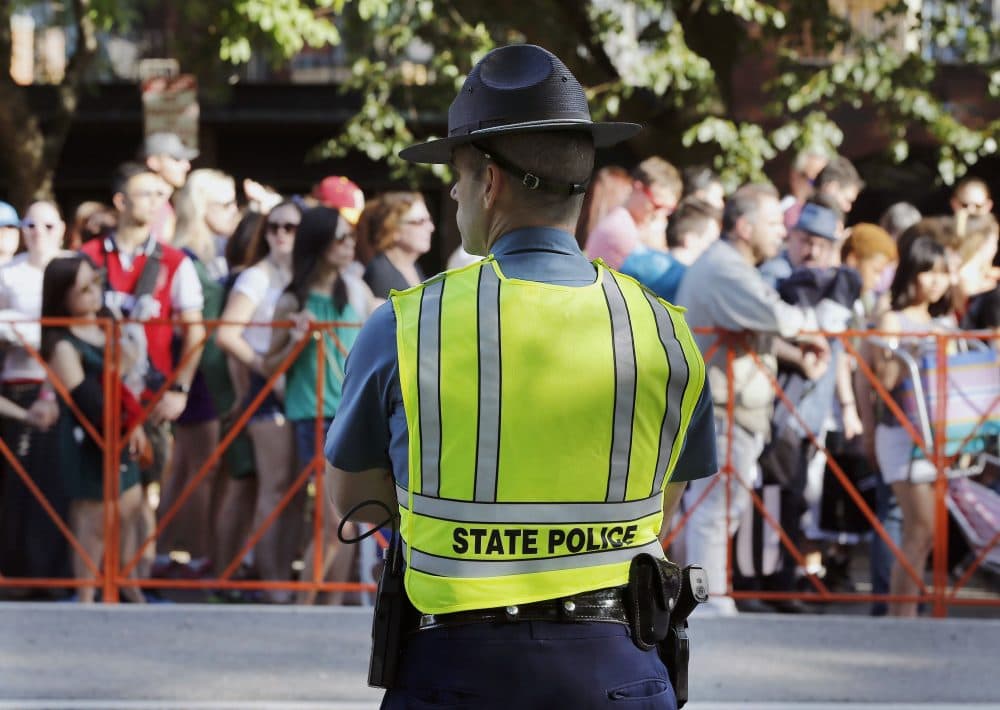 A Massachusetts State Police officer keeps watch over a line of people waiting to pass through security before rehearsal for the annual Boston Pops Fireworks Spectacular on the Esplanade in Boston in 2016. (Michael Dwyer/AP)