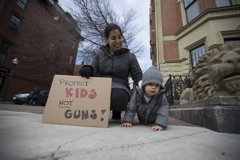 One-and-a-half- year old Aban meydani-Korv and his mother turn out on Columbus Ave to watch the march. (Jesse Costa/WBUR)