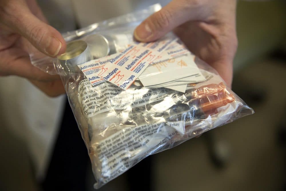 Dr. Laura Kehoe holds a kit for an intravenous user that includes the tools of active drug use: syringes, cookers and cottons. (Robin Lubbock/WBUR)