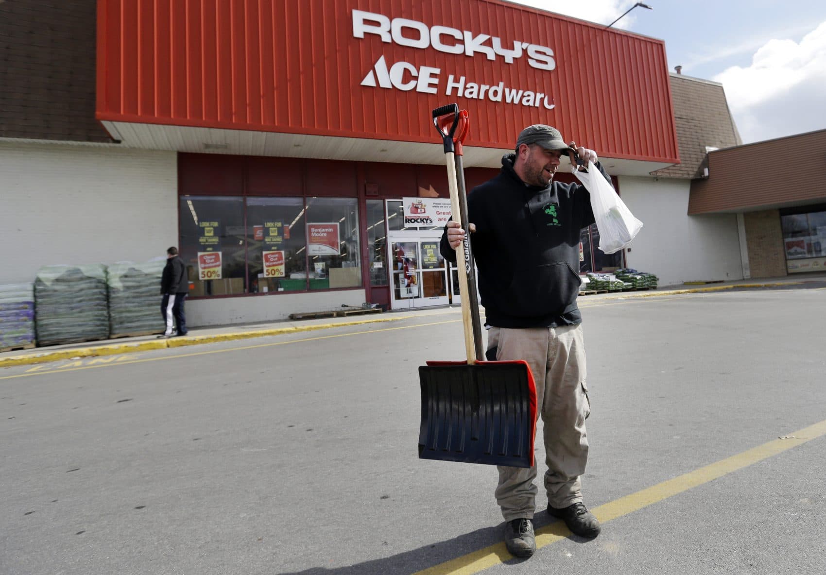 Marc Philibert, of McCarthy Landscaping, walks to his pickup truck after buying snow shovels at a hardware store Monday in North Andover. (Elise Amendola/AP)